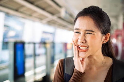 Closeup of young woman touching her face